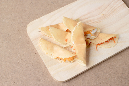 Thai pancake it is delicious snacks on wood background , Kind of Thai sweetmeat or Kanom Buang - Thai Style Crispy Tart or Thai sweetmeat with wood cutting board on wood backgroundの写真素材