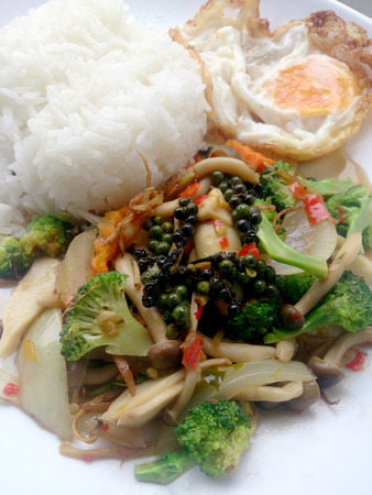 Stir-fried Black pepper with colorful vegetables & thai jasmine rice & fried egg in white dish isolate on white background. Vegetarian Food, Healthy food.の写真素材