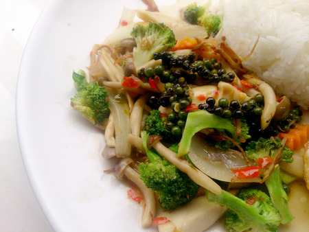 Stir-fried Black pepper with colorful vegetables & thai jasmine rice & fried egg in white dish isolate on white background. Vegetarian Food, Healthy food.の写真素材