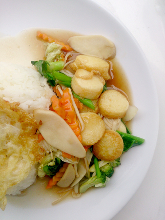 Stir Fried Tofu in Chinese Style,Deep Fried Tofu with Gravy Sauce ,Stir fried tofu with  mixed vegetables in white plate on white background. Vegetarian Food, healthy food.の写真素材