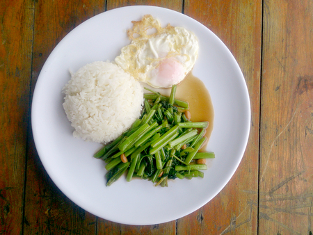 Food Thai in Asian, green morning glory vegetable fried oil with garlic food on wood table at outdoor sunlighte, Vegetarian Food, healthy foodの写真素材