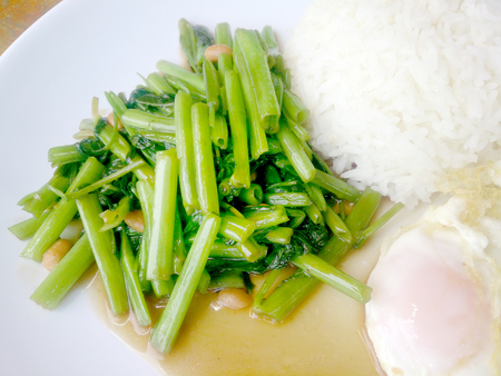 Food Thai in Asian, green morning glory vegetable fried oil with garlic food on wood table at outdoor sunlighte, Vegetarian Food, healthy foodの写真素材