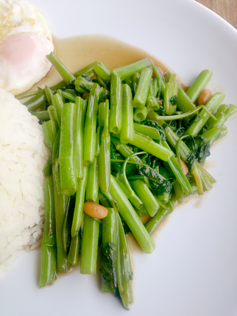 Food Thai in Asian, green morning glory vegetable fried oil with garlic food on wood table at outdoor sunlighte, Vegetarian Food, healthy foodの写真素材