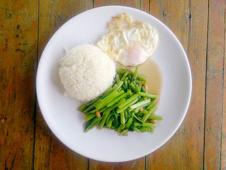 Food Thai in Asian, green morning glory vegetable fried oil with garlic food on wood table at outdoor sunlighte, Vegetarian Food, healthy foodの写真素材