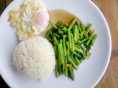 Food Thai in Asian, green morning glory vegetable fried oil with garlic food on wood table at outdoor sunlighte, Vegetarian Food, healthy foodの写真素材