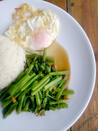 Food Thai in Asian, green morning glory vegetable fried oil with garlic food on wood table at outdoor sunlighte, Vegetarian Food, healthy foodの写真素材