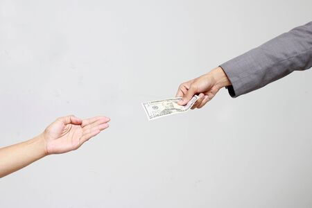 Businessman hand holding US dollar, USD. bills, offers dollar bank note money and giving money Paid for Something by Cash in Business Concept.の写真素材