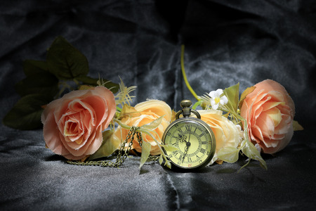 vintage pocket clock with rose flower on black fabric background. Love of time concept. still life styleの写真素材