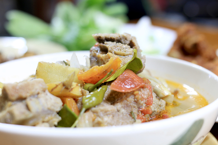hot and spicy soup with pork ribs with Thai herb in white blow on the table for dinner. Thai style food.の写真素材