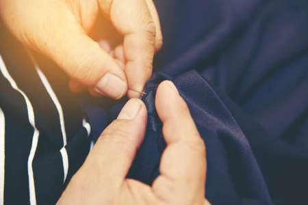 Closeup hands of Tailor man working in his cloth fabric in shop, Tailoring, close up.の写真素材