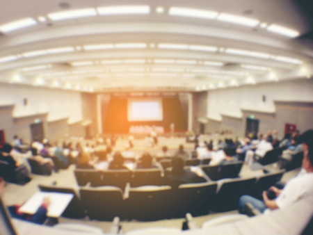 blurred image of Business Conference and Presentation. People Meeting Conference Seminar, Audience at the conference hall. - interior of a conference hall, warm & vintage tone photo.の写真素材