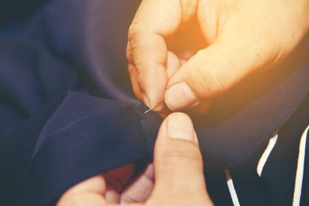 Closeup hands of Tailor man working in his cloth fabric in shop, Tailoring, close up.の写真素材