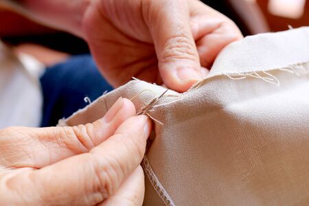 hands of seamstress at work on the wooden chair with her cloth , hand made soft toys sewing with felt and needleの写真素材