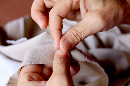 hands of seamstress at work on the wooden chair with her cloth , hand made soft toys sewing with felt and needleの写真素材