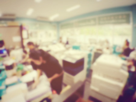blurred image of worker is working at modern office copy documents on machine for copy, document...