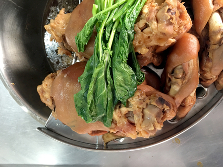Stewed pork leg "Khao Kha Moo" with vegetable on top prepare for serving with Egg and Rice at roadside restaurant, Thai street food.の写真素材