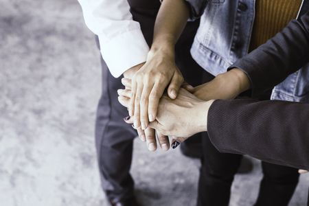 Close up of young business people putting and join their hands together. Team with stack of hands...