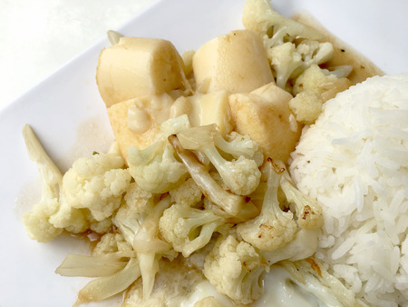Stir Fried Tofu in Chinese Style,Deep Fried Tofu with Gravy Sauce ,Stir fried tofu with cauliflower and thai style fried egg in white plate on white background. Vegetarian Food, healthy food.の写真素材