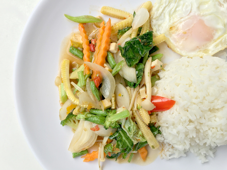 Stir mix vegetables  with gravy sauce and thai style fried egg in white plate on white background. Vegetarian Food, healthy food.の写真素材