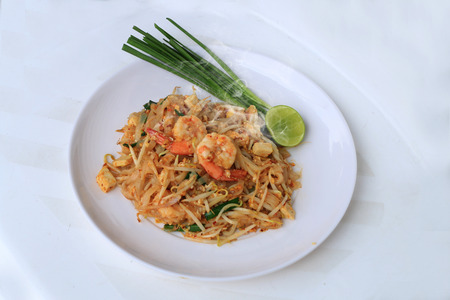Thai style noodles, Pad Thai, stir-fried rice noodles with shrimp serve with vegetable in white plate on white background. The one of Thailand's national main dish. the popular food in Thailand.の写真素材