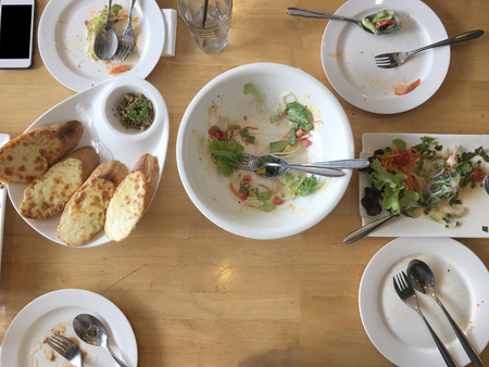 Enjoy eating. Top view of friends, family, group of people have eating healthy food together after vegetarian cooking classes while sitting at the wooden table. Group Of People Dining Conceptの写真素材