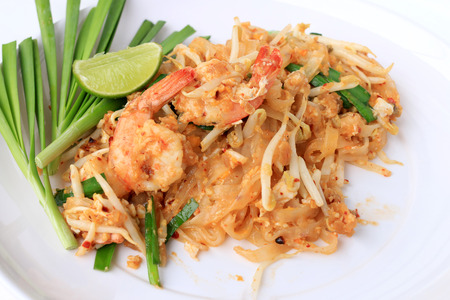 Pad Thai, stir-fried rice noodles with shrimp in white plate with slide lemon and green vegetable. The one of Thailand's national main dish. the popular food in Thailand. Thai Fried Noodlesの写真素材