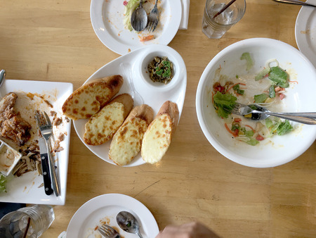 Enjoy eating. Top view of friends, family, group of people have eating healthy food together after vegetarian cooking classes while sitting at the wooden table. Group Of People Dining Conceptの写真素材