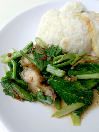 Stir fry Kai Land and crispy pork, stir fried rice with rice in white dish on white background. Thai style food.の写真素材