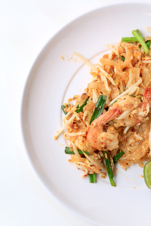 Pad Thai, stir-fried rice noodles with shrimp in white plate with slide lemon and green vegetable. The one of Thailand's national main dish. the popular food in Thailand. Thai Fried Noodlesの写真素材