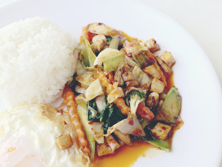 Homemade mini tofu stir fry, vegetables and chili paste with rice and fried egg in white dish on white background for celebrate Chinese new year festival. Healthy & Vegetarian  food. Thai style.の写真素材