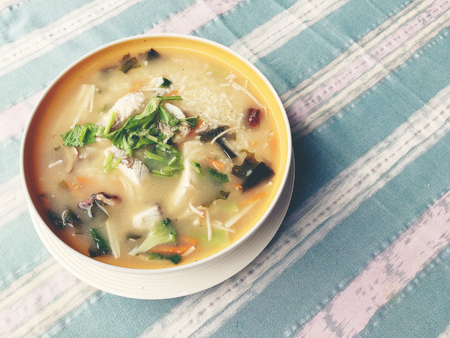 Homemade rice soup with vegetables and king fish in white bowl. Thai style food.の写真素材