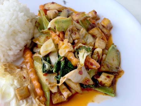 Homemade mini tofu stir fry, vegetables and chili paste with rice and fried egg in white dish on white background for celebrate Chinese new year festival. Healthy & Vegetarian  food. Thai style.の写真素材