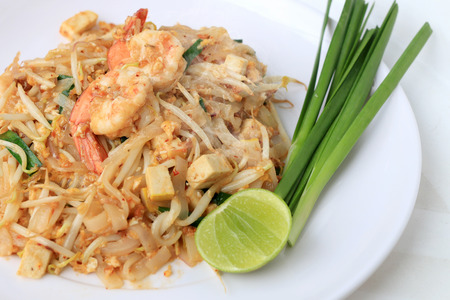 Thai style noodles, Pad Thai, stir-fried rice noodles with shrimp serve with vegetable in white plate on white background. The one of Thailand's national main dish. the popular food in Thailand.の写真素材