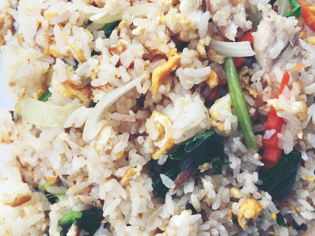 Asian fried rice with mackerel; egg and vegetable in white dish serve with slide cucumber on wooden background. Thai style food.の写真素材