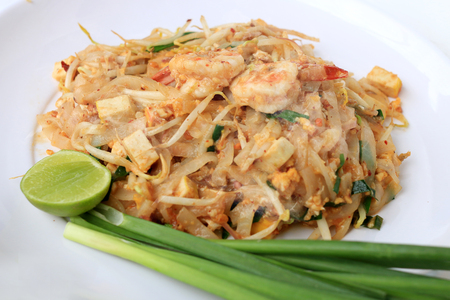 Thai style noodles, Pad Thai, stir-fried rice noodles with shrimp serve with vegetable in white plate on white background. The one of Thailand's national main dish. the popular food in Thailand.の写真素材