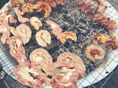 Grilled chitterlings or roast chitterlings on the stove, after finish for sale in dish,Thai food. vintage tone filter color.の写真素材
