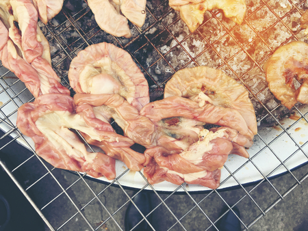 Grilled chitterlings or roast chitterlings on the stove, after finish for sale in dish,Thai food. vintage tone filter color.の写真素材