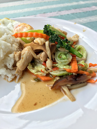 stir-fried vegetables with thai jasmine rice and fried egg in white dish as food for people who need control fat.の写真素材