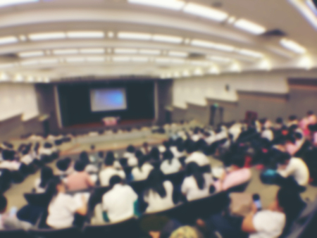 Education concept, Abstract blurred background image of students and business people  studying and discuss in large hall profession seminar with screen and projector for showing information.の写真素材