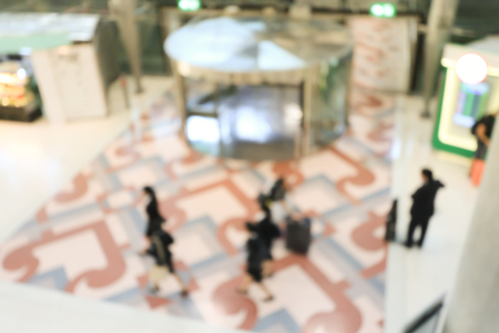 blurred image of crowd of travelling people or passenger walking with a luggage from flight in the international airport terminal with beautiful bokeh from the light,advertise & traveling concept.の写真素材