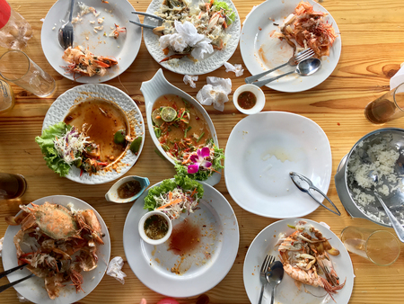 Family or friends in summer party or seafood set dinner. Flat-lay of group of mutinational people at big table eating delicious food together. Summer gathering or celebration. top view background.の写真素材