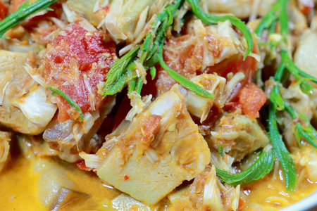 Northern Thailand local food called Kaeng Khanun-on is cooking like a young jack fruit soup with pork spare rib Thai herb, Climbing Wattle, Acacia pennata, red eggplant in white bowl on wooden table.の写真素材