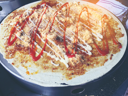 Farmers creperie is cooking Charcoal Crepe with fog ,hot,sauces and dried shredded pork, vendor peforms how make pancakes or crepes at street food market.の写真素材