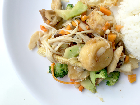 Stir fry yellow tofu and vegetable with rice and fried egg in white dish on white background for celebrate Chinese new year festival. Healthy food. Thai food.の写真素材
