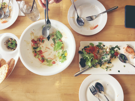 Enjoy eating. Top view of friends, family, group of people have eating healthy food together after vegetarian cooking classes while sitting at the wooden table. Group Of People Dining Conceptの写真素材