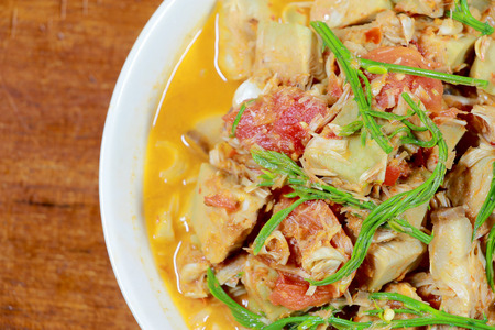 Northern Thailand local food called Kaeng Khanun-on is cooking like a young jack fruit soup with pork spare rib Thai herb, Climbing Wattle, Acacia pennata, red eggplant in white bowl on wooden table.の写真素材