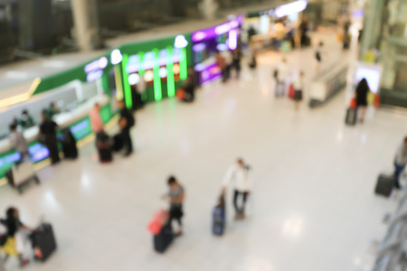 blurred image of crowd of travelling people or passenger walking with a luggage from flight in the international airport terminal with beautiful bokeh from the light,advertise & traveling concept.の写真素材