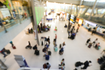 blurred image of crowd of travelling people or passenger walking with a luggage from flight in the international airport terminal with beautiful bokeh from the light,advertise & traveling concept.の写真素材