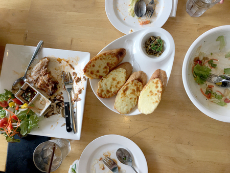 Enjoy eating. Top view of friends, family, group of people have eating healthy food together after vegetarian cooking classes while sitting at the wooden table. Group Of People Dining Conceptの写真素材