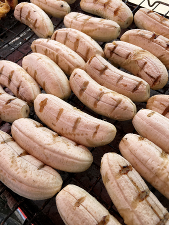 Close-up of grilled banana, Thai dessert in market, Roasting bananas on stove, Dessert by grilling banana on the hot charcoal, (Thailand traditional snacks/dessert). Street Food in Thailand, Vietnamの写真素材